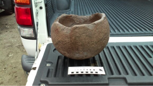 Side view of ancient stone pot displayed in bed of pickup truck