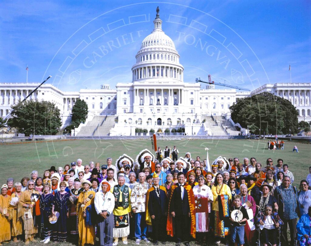 Large group of people in mix of traditional and modern attire representing Tribes from across the continent standing in front of the U.S. Capitol